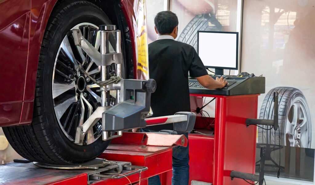 Wheel alignment, a car on a stand with sensors on the wheels to assess the camber of the wheels in the service station's workshop.